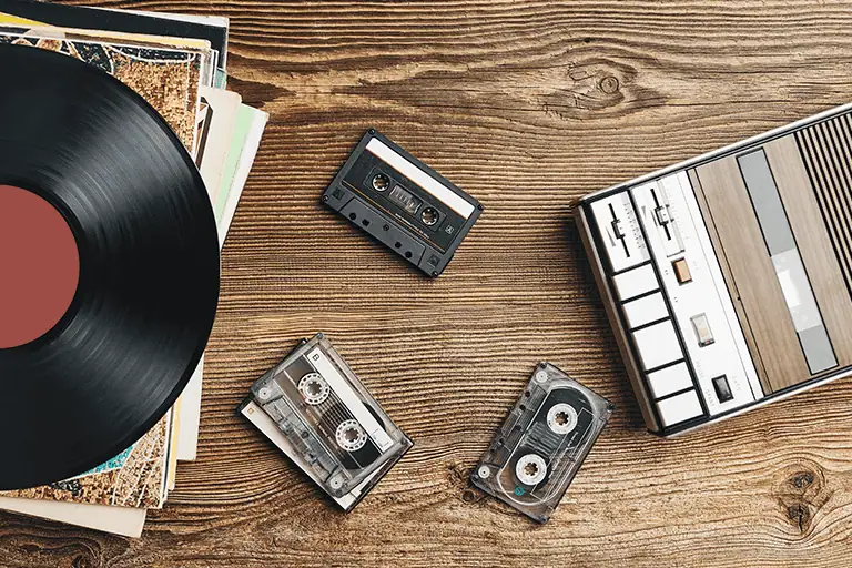 A vinyl record, tape player and tapes, how your music is produced will determine the sync licensing fees in 2026, our clients secured 34 production music library placements averaging £332 each versus 12 artist catalogue placements averaging £2,800 each. 