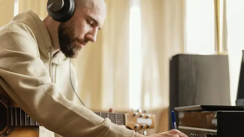 A musician making notes to plan his music career goal settings