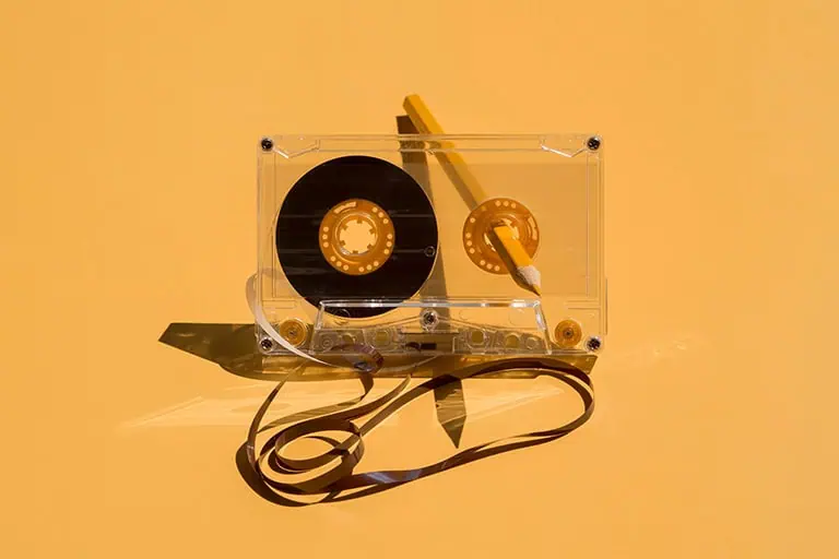 Tangled cassette tape with exposed magnetic tape spilling out from the plastic casing, representing obsolete music marketing tactics like interest targeting and lookalike audiences that Meta's December 2024 Andromeda update replaced