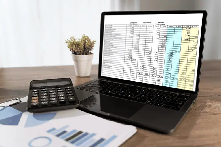 Laptop screen showing a financial report with calculator and business chart, representing analysis of disputed royalty payment records