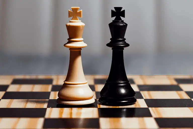 Two chess kings facing each other on a chessboard, like the record labels and AI companies moving from courtroom battle to negotiated deal